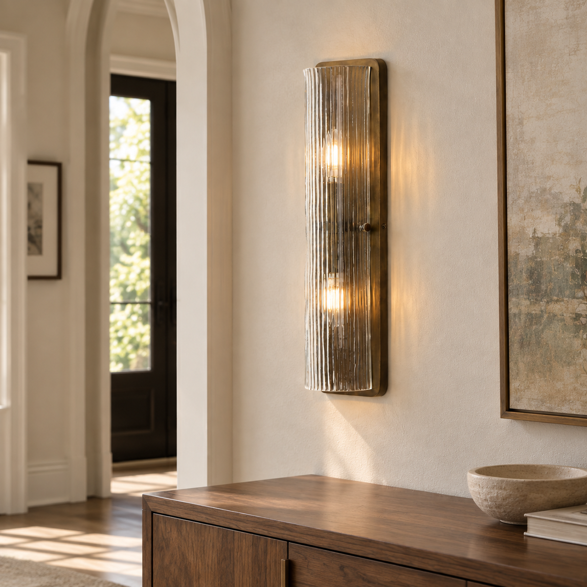 Kiera Burnished Brass wall sconce above an entry console