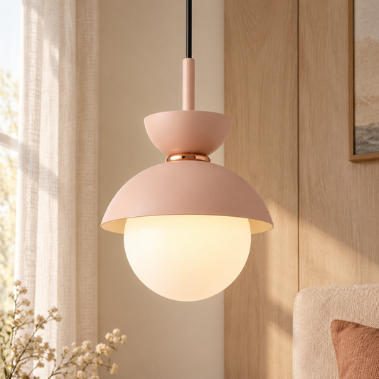 Blush pink Zosia globe pendant light installed in a soft bedroom