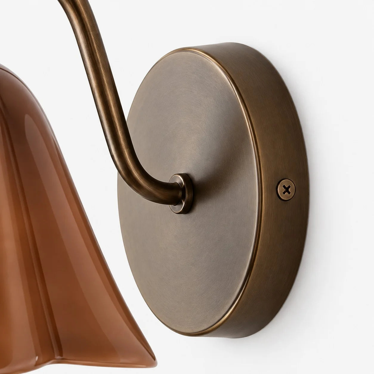 Close-up of the aged brass backplate and curved arm